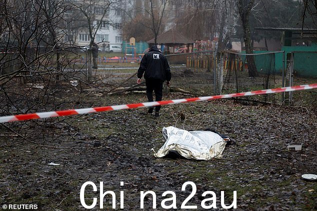 1 月 18 日,在基辅郊外的 Brovary 镇,一具尸体躺在一架直升机坠落在民用基础设施建筑的现场的地面上