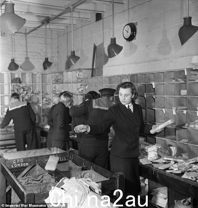 1944 年,岸上舰队邮政办公室的繁忙景象,可能是在朴茨茅斯。Wrens 和皇家海军的船员们正在努力分拣收到的邮件,以便继续投递到the ships moored in the harbour