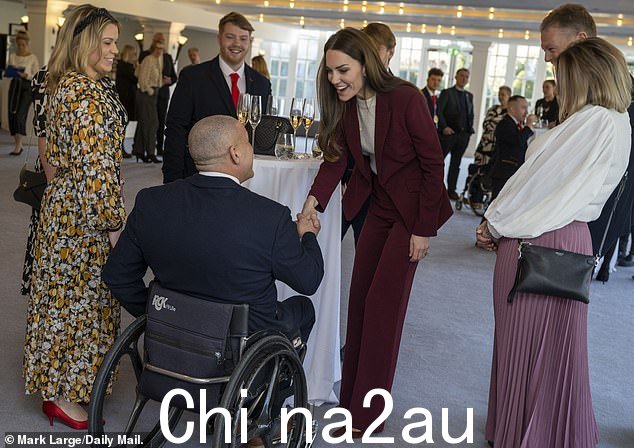 威尔士王妃在汉普顿宫的招待会上与客人握手