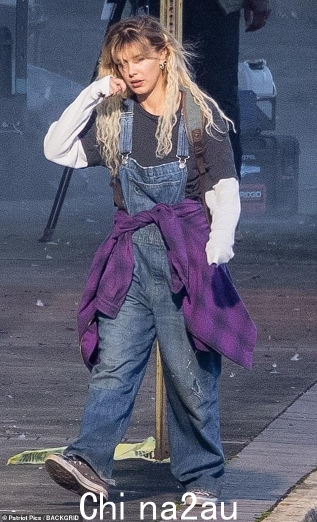 现场拍摄:这位 18 岁的女演员身穿超大号牛仔背带裤,留着长长的金发,同时在佐治亚州亚特兰大拍摄即将上映的科幻冒险电影的场景