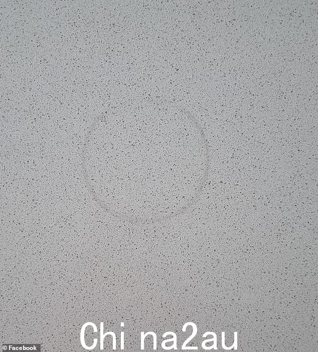 一位妈妈伤心地发现一杯红酒弄脏了她的白色石材柜台