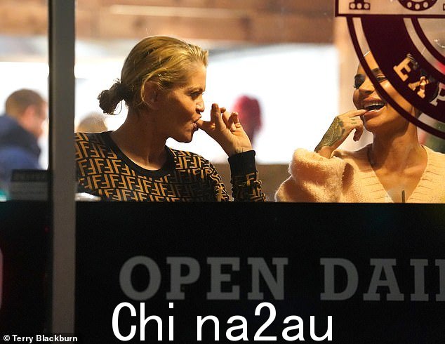 朋友约会:他们在快餐店的橱窗里享用了丰盛的晚餐,使当她舔干净手指时,一定不要错过任何一点食物