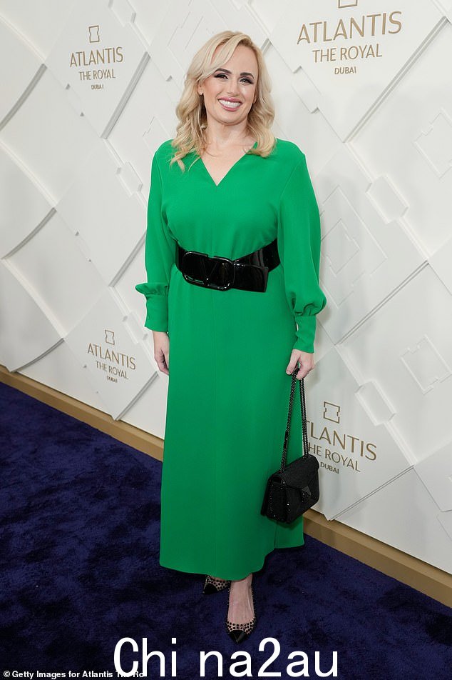 好莱坞明星:Rebel Wilson 身着亮绿色连衣裙,腰间系着粗黑腰带走上开幕式