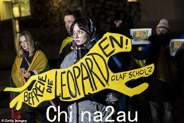 一名抗议者举着一个标语,上面写着“自由e leopards Olaf Scholz' 作为示威者,其中许多是居住在柏林的乌克兰人,他们的座右铭是:在总理府外“释放豹子”,要求德国派遣乌克兰豹式主战坦克,1 月 20 日“class=