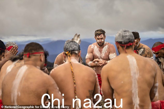 Chris Hemsworth 在新南威尔士州北部 Wright's Lookout 与土著舞者一起参加文化仪式时被涂成白色赭石并穿着红色大衣