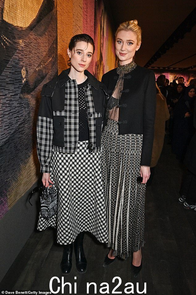 Elizabeth Debicki 身穿金色网眼上衣和单色图案裙子,闪耀她的胸罩,与酷似姐姐 Catherine 一起观看 Dior 的巴黎时装周秀
