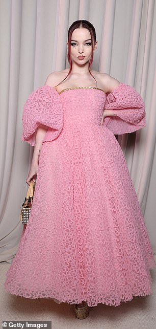 漂亮:她在红地毯上摆姿势拍照时加入了古怪的 Dove Cameron。