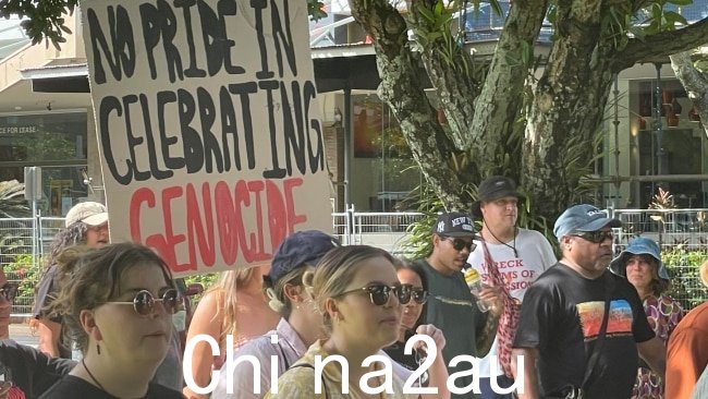 抗议者在昆士兰州的 Fogarty 公园举着反对 genoice 的标语。图片: Andrew McKenna