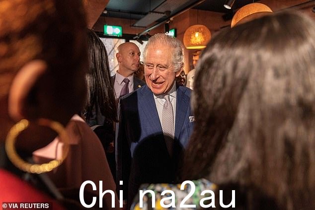 这次访问的照片显示查尔斯高兴地讲话与会者一起大笑的与会者