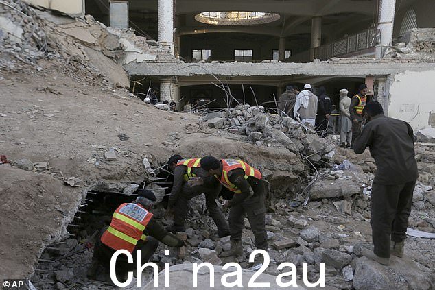 2023 年 1 月 31 日,在巴基斯坦白沙瓦,当局完成救援行动后,救援人员和人员聚集在星期一的自杀式爆炸现场