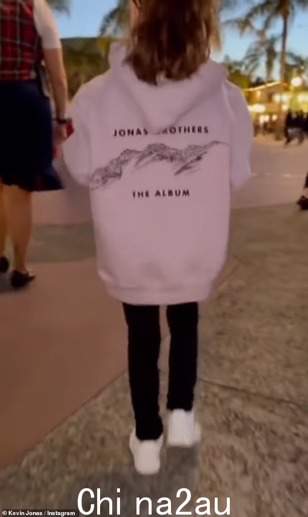 支持爸爸:Alena 在剪辑中穿着 Jonas Brothers 连帽衫