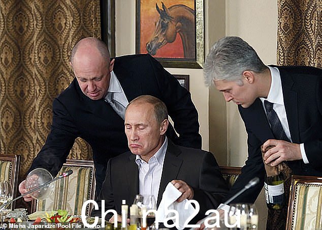 由于它采用绞肉机的作战方式,一波又一波的应征入伍者被驱赶到枪林弹雨、坦克和大炮的火力中,士气从未如此低落。图为:Evgeny Prigozhin(左)在 2011 年的一次晚宴上协助 Vladimir Putin