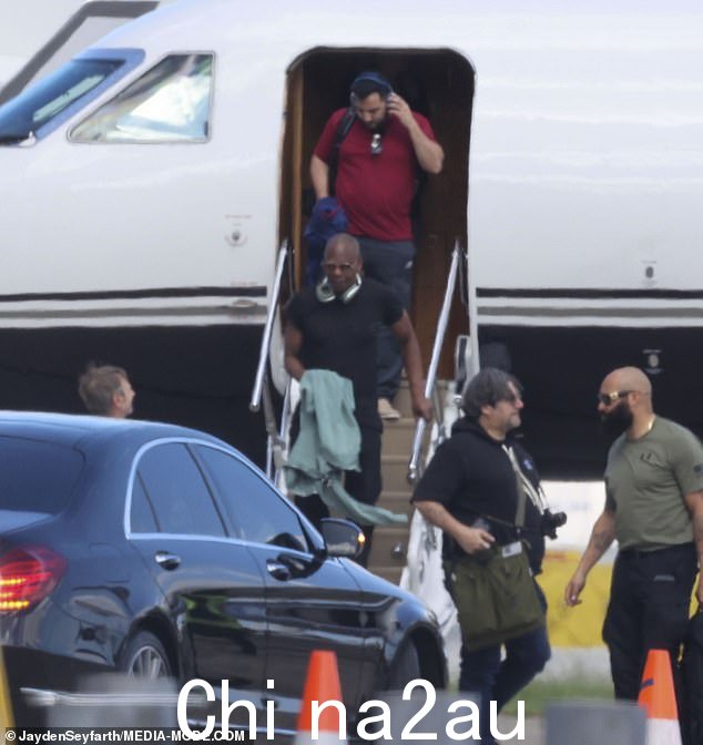 一辆华丽的黑色轿车等待着 Chappelle,他的几名随行人员陪同