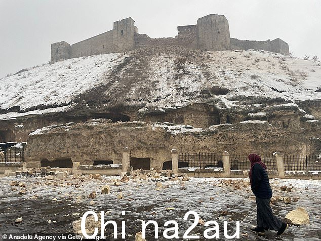 图:一位女士走过历史悠久的加济安泰普城堡,该城堡在周一早上的地震中受损