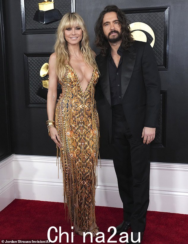 可爱的情侣:海蒂·克鲁姆 (Heidi Klum) 和丈夫汤姆·考利茨 (Tom Kaulitz) 周日在洛杉矶出席第 65 届格莱美颁奖典礼时,身着华丽的金色礼服大跳水” class=