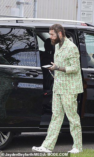 照片显示 Post Malone 从一辆黑色汽车中走出来,当机组人员准备他的喷气式飞机起飞时,他正盯着他的手机