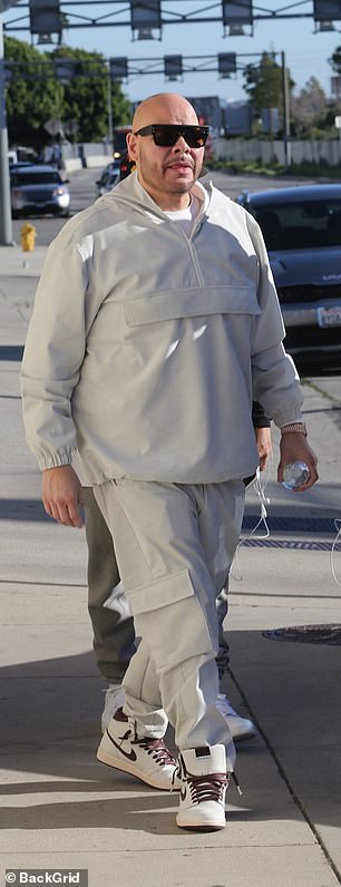 休闲酷:Fat Joe 穿着灰色运动衣和一双白色和紫色耐克运动鞋