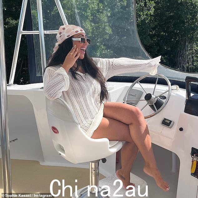 Happy: Sophie 换上了一件奶油色毛衣,坐在豪华游艇的舵轮后面,看起来很开心