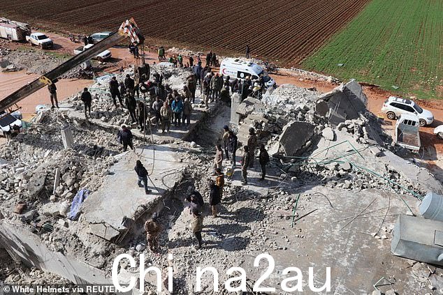 图:2023 年 2 月 7 日在叙利亚 Al Atareb 发生地震后,救援队的成员聚集在废墟上继续寻找幸存者