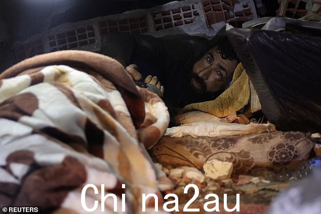 当救援人员将一盏灯照进废墟的范围内时,Abdulalim Muaini 眯着眼睛看着他们并伸出一只手。他被夹在倒塌的混凝土板和地板之间,和他妻子毫无生气的身体