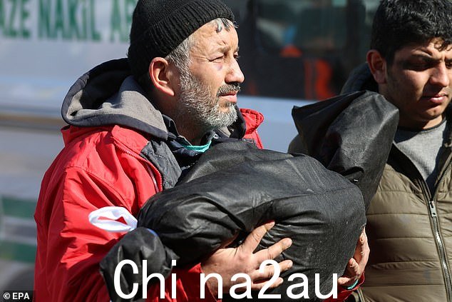加济安泰普市的 Islahiye 区在两次地震后被夷为平地,一位悲痛的父亲背着孩子的遗体去世