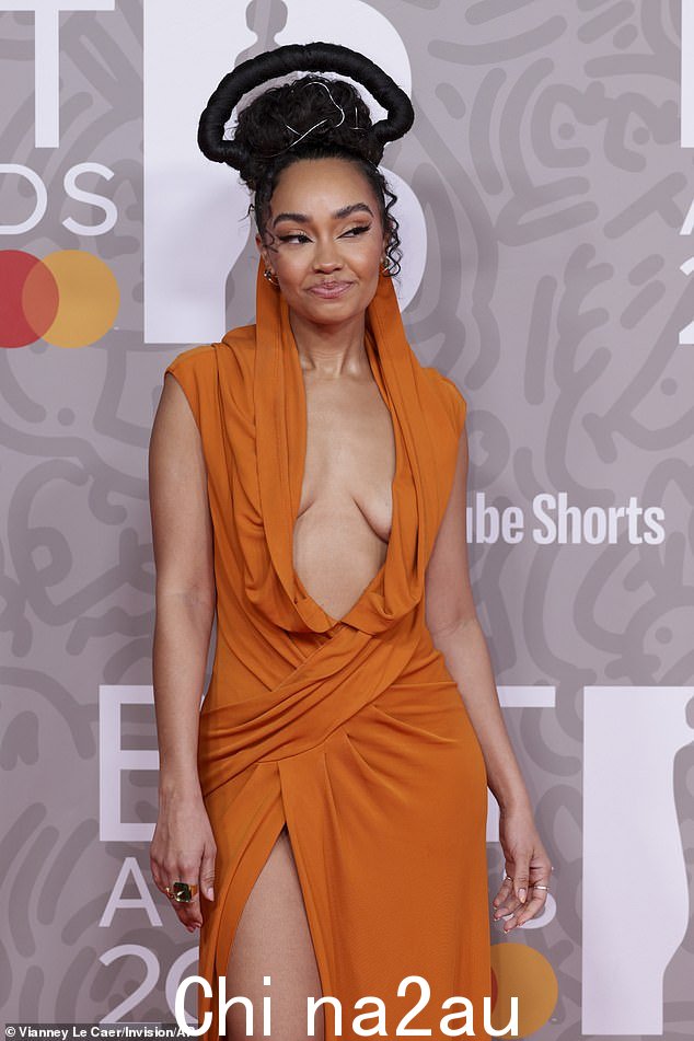 回头率:这位 31 岁的 Little Mix 歌手穿着一件带有大胆高开衩的橙色垂褶礼服,从头到脚看起来都令人难以置信