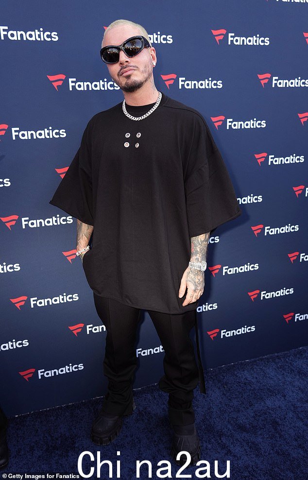 黑衣人:J Balvin,37 岁,穿着宽松的黑色 T 恤和配套的裤子和鞋子