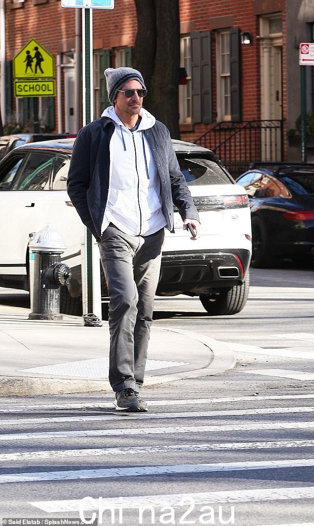 Bradley's look: 这位演员戴着灰色长筒袜出门,戴着黑色太阳镜保暖,留着早期的邋遢山羊胡子