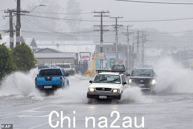 汽车穿过被洪水淹没的道路在热带气旋加布里埃尔袭击新西兰北部城市旺格雷时