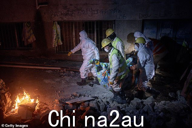 2 月 14 日,救援人员将 45 岁的 Mujde Cavlak 的尸体从被毁建筑物中运走后,用毯子裹着