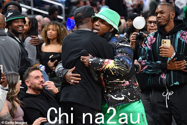 问候:小拳击手弗洛伊德梅威瑟在中场休息时被说唱歌手 Jacquees 拥抱
