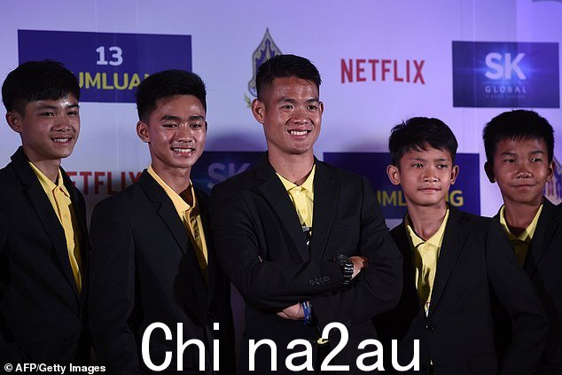 图:野猪队成员与教练 Ekkapol Chantawong(中)在曼谷举行的新闻发布会上合影2019 年 4 月 30 日关于从 Tham Luang 洞穴营救团队的 Netflix 系列节目