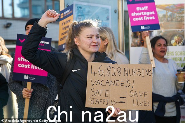 NHS 在罢工中严重短缺 12,000 名医院医生和 50,000 多名护士和助产士。图为:2 月 6 日,一名护士在威斯敏斯特圣托马斯医院外作为皇家护理学院纠察队员举着标语牌