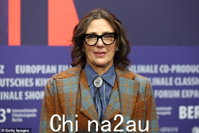 华丽:60 岁的 Rebecca 导演穿着带有蓝色格子设计的棕色西装进行智能展示