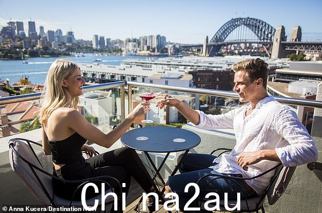 新宣传活动吹嘘能源费用——今年在英国高达 2,600 英镑——在澳大利亚将花费近一半,节省下来的钱用于喝酒和外出就餐(如图 - 情侣饮酒在 Henry Deane 的屋顶鸡尾酒酒廊,Hotel Palisade,Millers Point,澳大利亚)