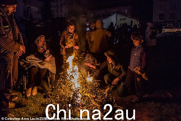 当地人在撤离靠近土耳其与叙利亚边境的家园后围坐在火边