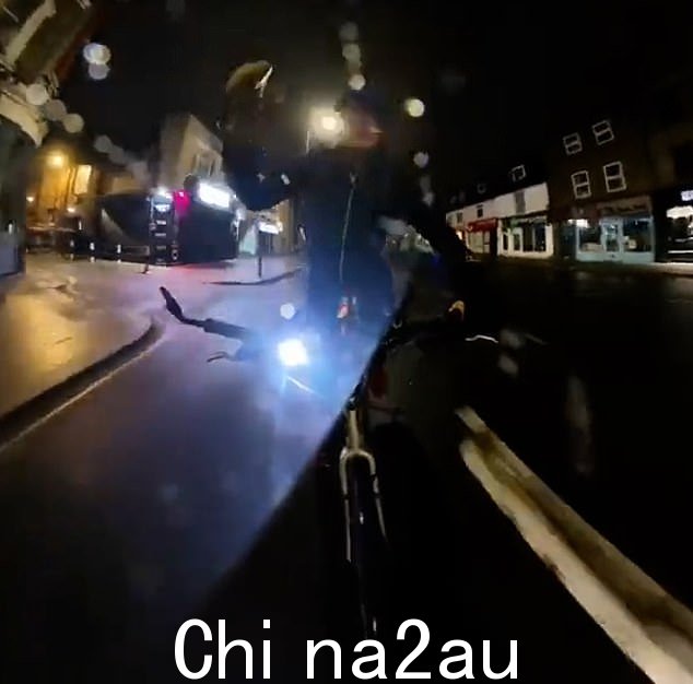 反向视图显示 Vine 先生在黑暗中骑车穿过 Hammersmith 时正在使用他的自行车上的灯