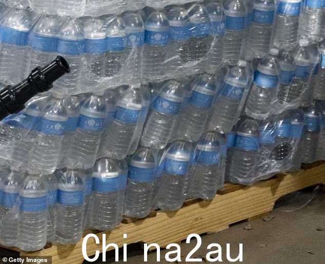 侧面印有特朗普标志的一叠瓶装水被推到东帕尔estine 消防局派发给 19 天前出轨的居民