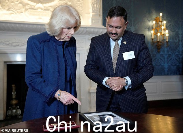 英国的卡米拉,王后与豪恩斯洛议会领袖山塔努·拉贾瓦特议员站在一起