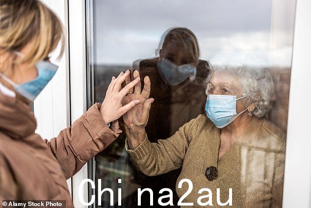 2020 年 3 月下旬,检测和 PPE 危机将疗养院变成了“战区”进入锁定状态。图为一名妇女在大流行期间独自探望她的祖母