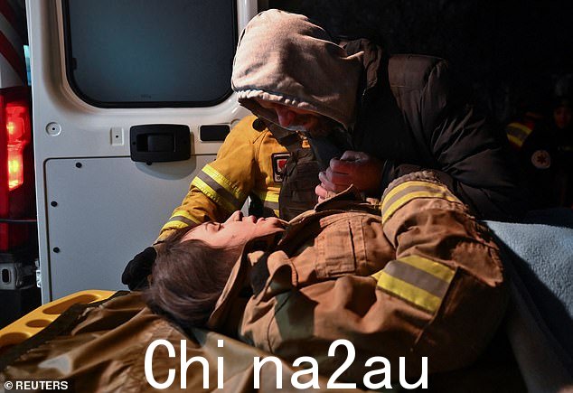 当地居民 Yurii 握着他怀孕的亲戚安娜的手,她 27 岁,她从一栋被俄罗斯导弹袭击严重损坏的住宅楼中获救