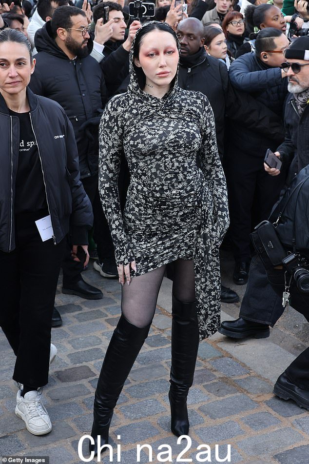 多么漂亮的衣服啊!诺亚赛勒斯 (Noah Cyrus) 身着黑色褶皱迷你连衣裙,搭配腰带和及膝黑色皮靴,炫耀她的双腿