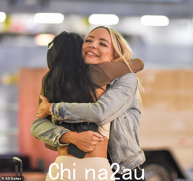 女朋友们都笑了,因为他们在外面的行李认领处见面并分享了一个拥抱