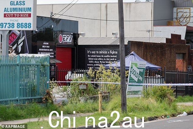 警方2023 年 3 月 2 日星期四,在悉尼塞夫顿的 Elite Fight Force 混合武术馆外,医务人员检查了致命枪击现场。 <p class=