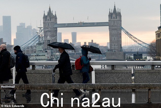 伦敦:本周英格兰部分地区也可能出现寒冷和多雪的天气。照片中的通勤者今天早上在雨中和冰冻温度下