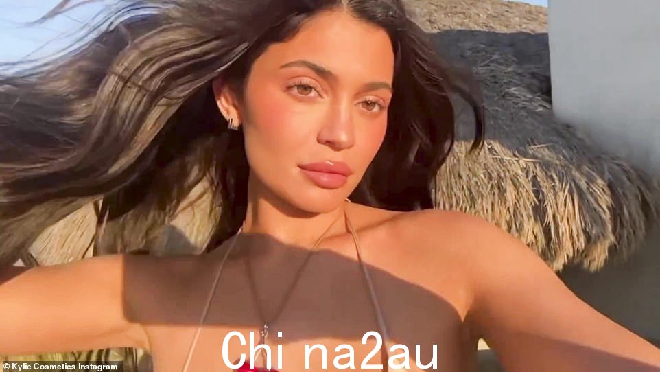 Glow for it:Kylie Jenner 在周一早上分享到 Instagram 的闪回视频中穿着一件轻薄的米色比基尼上衣,看起来比以往任何时候都好看