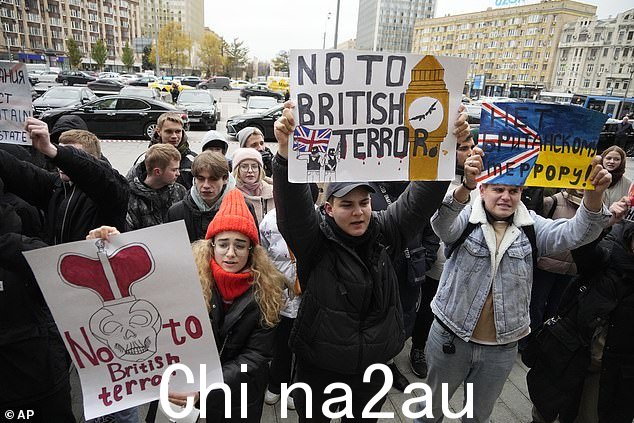 抗议者 - 似乎受到舞台管理 - 举着标语,上面写着'英国是一个恐怖主义国家'和'英国将为北溪负责'
