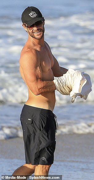 撕裂:39 岁的 Chris Hemsworth 周一在澳大利亚升温并去海滩冲浪时炫耀了他肌肉发达的体格