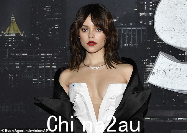 黑白装束:这位 20 岁的女演员身穿白色领口深 V 型衬衫裙和黑色宽翻领夹克,露出她裸露的肩膀