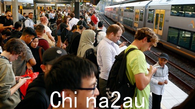 悉尼中央车站的通勤者在整个火车系统瘫痪后等待回家。图片：Richard Dobson